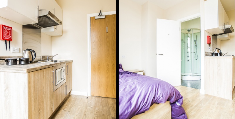 plit view of studio room: kitchen with fire safety and purple bed with shower area