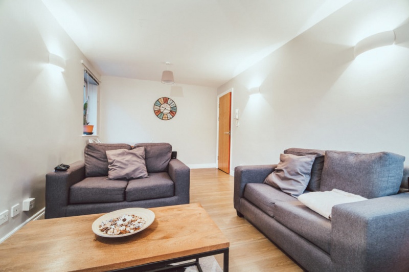 Comfortable living room with grey sofas, a coffee table, and soft lighting