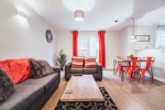 Cozy living room with grey sofas, red accents, and a wooden coffee table.