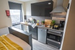 Studio with kitchenette, bed, desk, and storage at Oxford House student accommodation