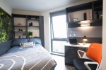 Private en-suite room with bed, desk, and storage at Oxford House student accommodation