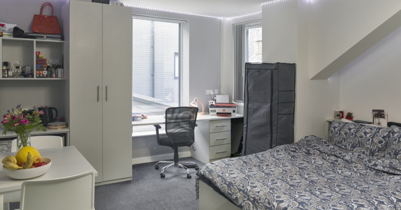 student bedroom with bed, desk, and storage at Canterbury Hall 