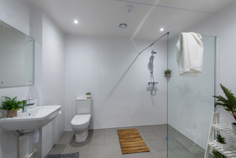 Accessible bathroom with a walk-in shower, toilet, and sink at the Valentine London