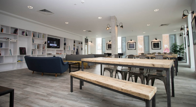 Bright common room at The Union, equipped with comfortable seating and tables for socializing among 