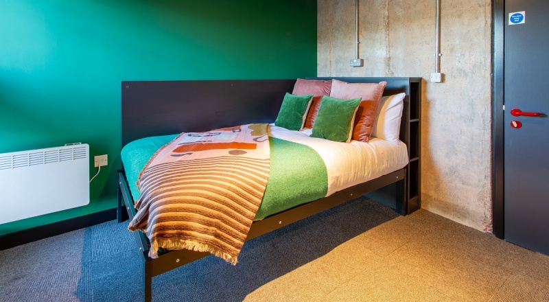 Cozy bedroom at Béton House student accommodation in Sheffield with a study desk and wardrobe