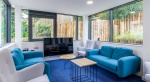 Modern common room at Goods Corner in Edinburgh with blue and grey furniture, garden views, and vari