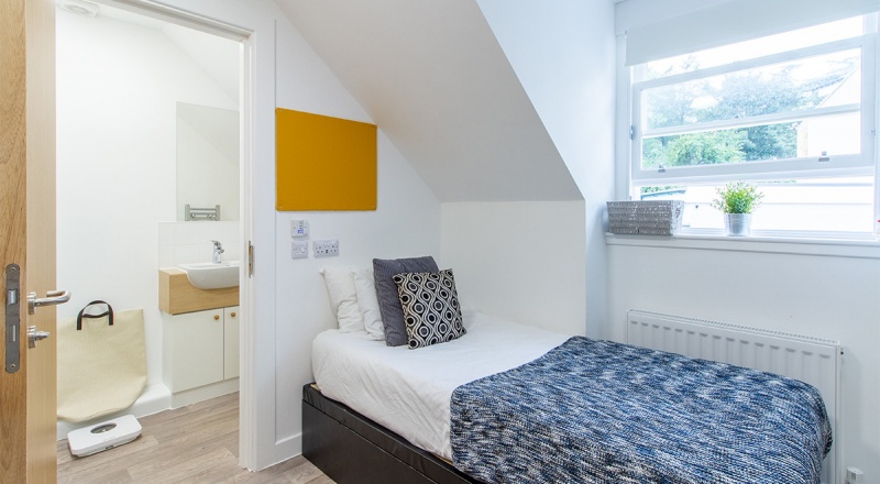 studio accommodation at Goods Corner with a single bed, desk, kitchenette