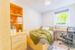 Student bedroom at Beech Gardens, Birmingham, features a bed, desk, and storage