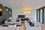 Common room at Beech Gardens featuring comfortable sofas, a pool table, and a neon sign