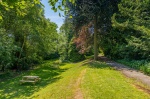 Lush green outdoor area at Beech Gardens with picnic tables, perfect for relaxing and enjoying natur