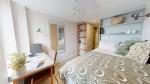 A spacious bedroom at Cosmos Sheffield accommodation with a study desk, bed, and decorative pillows