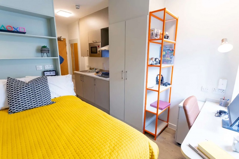 Studio room at Seren student accommodation in Swansea, showing a bed, kitchen, and study area