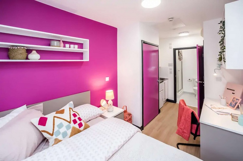 bedroom with pink details and desk and chair in Crosstrend House student accommodation