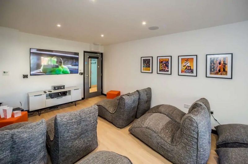 Cinema room with bean bag chairs and large TV in Crosstrend House