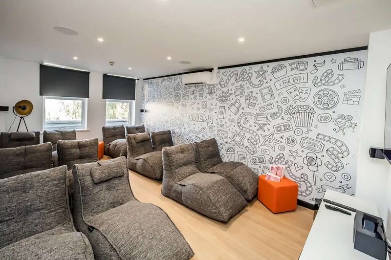 Cinema room with bean bag chairs and large TV in Crosstrend House