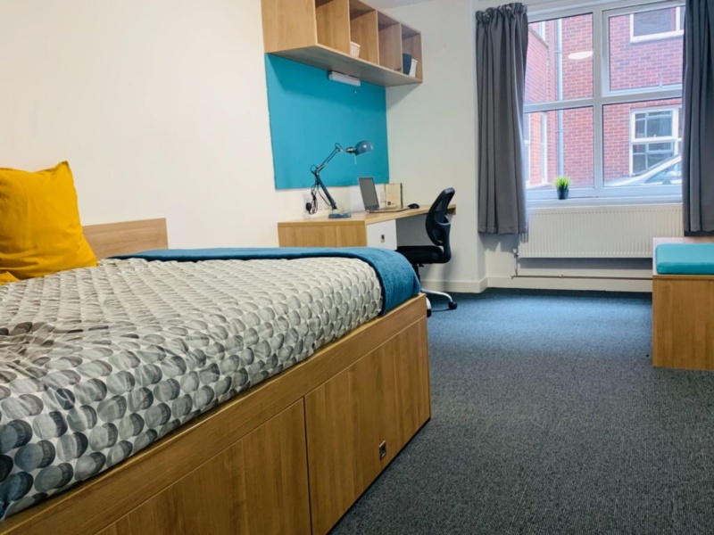 Comfortable bedroom with bed, desk, and storage at at Pennine House by Mezzino