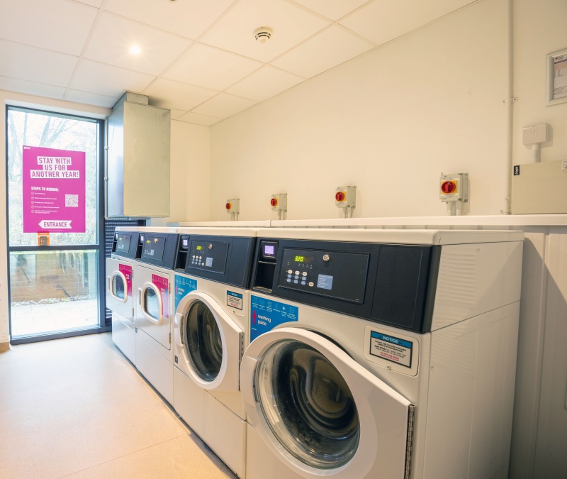 On-site laundry facilities with multiple washing machines and dryers for resident use