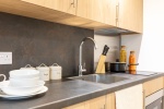 A close-up view of the kitchen in a standard townhouse studio, showcasing modern appliances and cabi