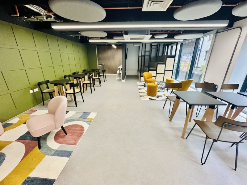 Spacious common area with lounge seating and study tables at The Nest