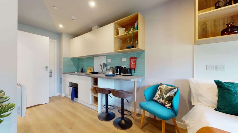 Modern kitchen with light cabinetry, stove, and microwave.