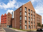 The building's exterior, showcasing a modern design with brick walls and large windows.