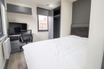 Studio room with bed, study desk and window at Trinity Hall in Leeds