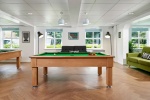 Games room at Snow Island student accommodation Huddersfield featuring pool tables and sofas