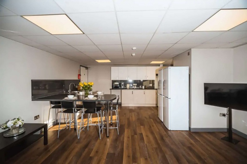 Open-plan common area with dining table and kitchen at The Junxion in Lincoln.