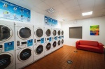 Laundry Room: Laundry room with multiple washers and dryers and a red couch.