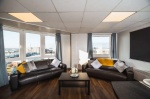 Lounge Area:Spacious lounge area with leather sofas, large windows, and city views