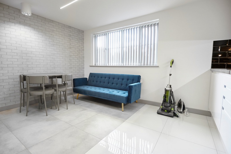 Communal living area with seating and TV at Beechwood House and Gardens