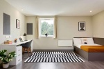 A classic ensuite bedroom with modern furnishings and a study area, offering a comfortable living sp