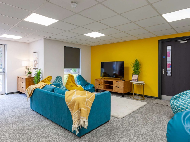 Colorful communal lounge with TV, sofas and armchairs for students in Foundry Court, Preston