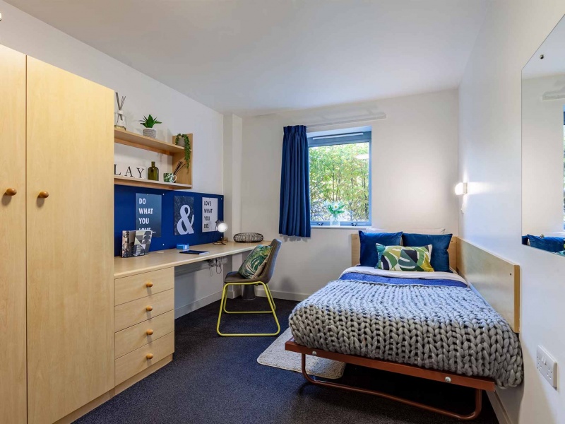 Comfortable bedroom with bed, desk, and storage at Polhill Park